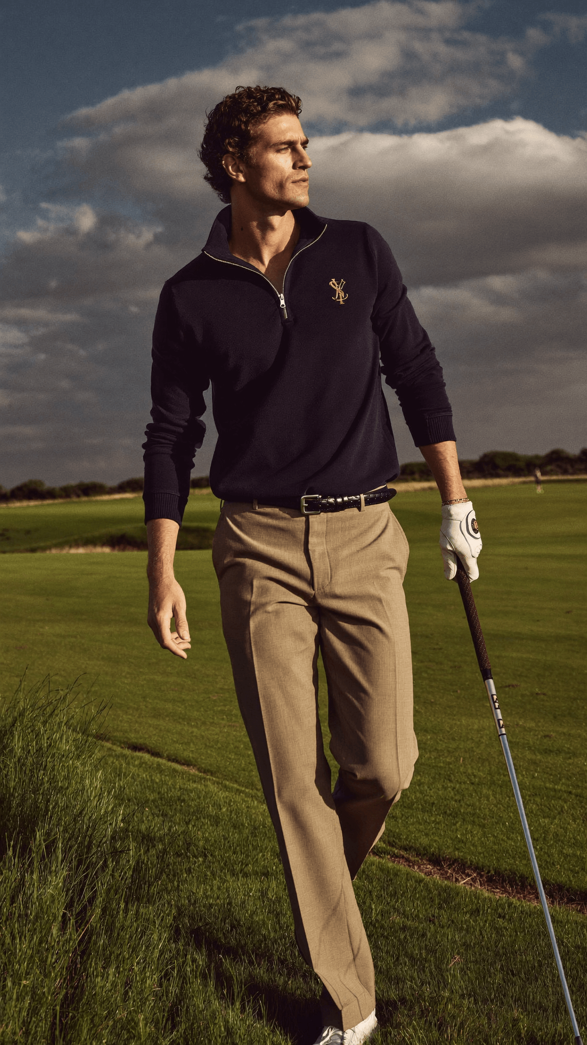 Golfer wearing House of Par apparel walking on a British links course at golden hour
